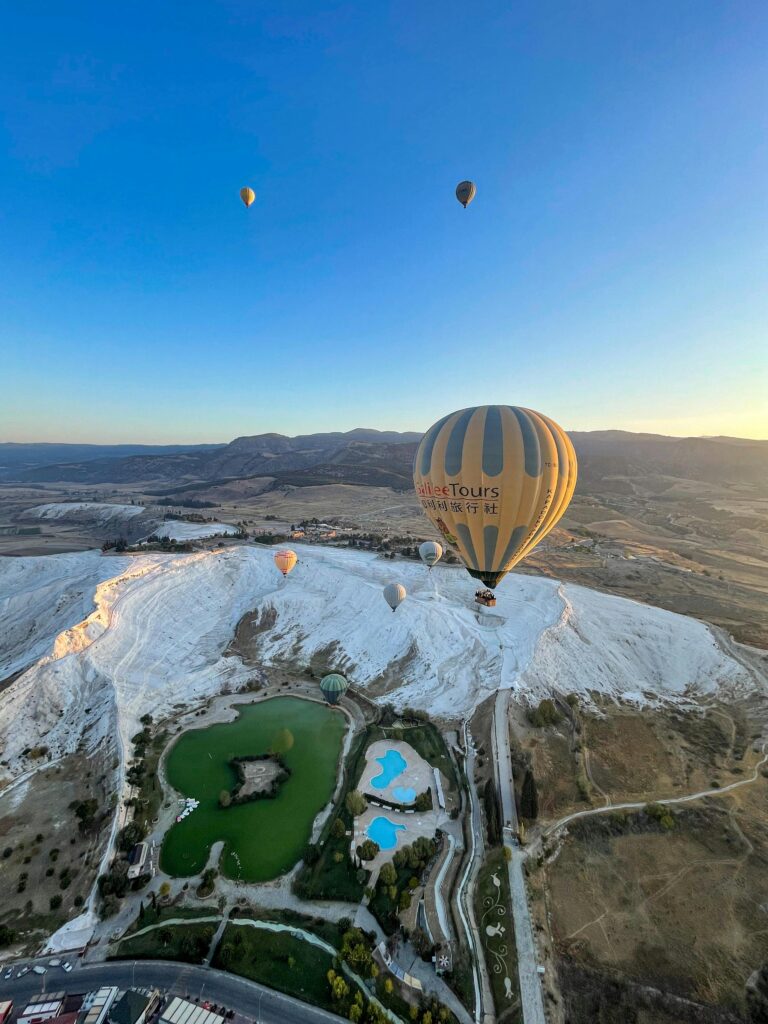 pexels-photo-28346229-28346229 Hot air balloons soar above the stunning white terraces of Pamukkale, Turkey during sunset.